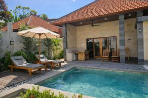a swimming pool with an umbrella and a house at Taman Senang - Private Pool Villas - Gili Air in Gili Islands