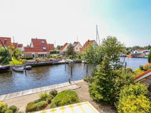 a river with houses and boats in a city at Park De Markol Tureluur 13 in Lemmer