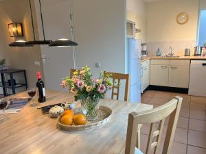 a kitchen with a table with a vase of flowers at Park De Markol Tureluur 13 in Lemmer +15 photos