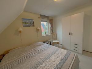 a bedroom with a large bed and a window at Park De Markol Tureluur 13 in Lemmer