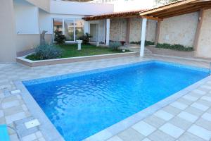 a swimming pool in the backyard of a house at Apartments&Rooms Jelavić in Seget Vranjica