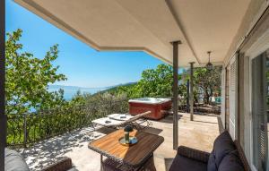 an outdoor patio with a table and a grill at Pet Friendly Apartment In Matulji in Matulji