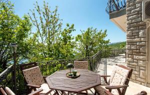 a wooden table and chairs on a balcony at Pet Friendly Apartment In Matulji in Matulji +26 photos