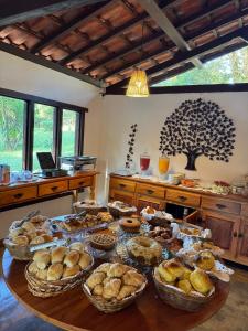 a table with many baskets of bread and pastries at Pousada Villa da Serra in Brumadinho
