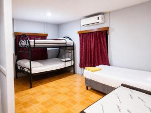 a small room with two bunk beds in it at hotel Oasis Managua Experience - HOME in Managua