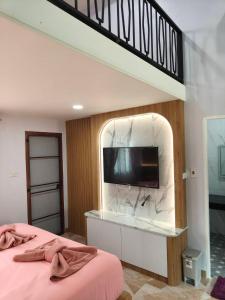 a bedroom with a tv on a wall at นนท์ ณ in Ban Non Makhuk