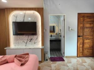 a room with a tv on a wall with a bathroom at นนท์ ณ in Ban Non Makhuk
