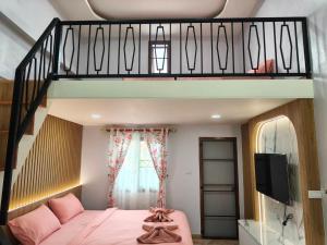 a bedroom with a pink bed and a loft at นนท์ ณ in Ban Non Makhuk