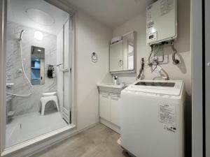 ein weißes Badezimmer mit Dusche und Waschbecken in der Unterkunft ハミルトンイースト in Sapporo + 117 Fotos