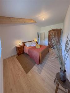 a bedroom with a bed and a potted plant at Maison de campagne T3 Nature in La Martre
