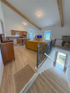 a living room with a staircase and a kitchen at Maison de campagne T3 Nature in La Martre