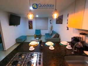 a kitchen with a counter top with a sink and a stove at Apartamentos Quedate en Anavi San Gil Plaza in San Gil