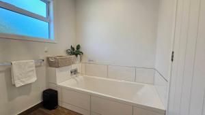a white bathroom with a tub and a window at "Great Scott" Great spot your Tekapo Retreat in Lake Tekapo +10 photos