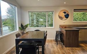 a kitchen with a table and chairs and windows at "Great Scott" Great spot your Tekapo Retreat in Lake Tekapo