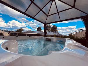 a large hot tub with an umbrella in a backyard at Emmaus Hill in Blue Haven