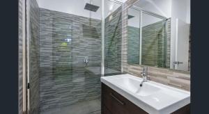 a bathroom with a sink and a glass shower at Rainforest Escape moments from Waterfall in Kuranda +9 photos