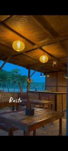 a wooden table with lights on top of a beach at El-Mindri Bungalow dan Resto in Gili Gede