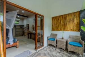 a living room with chairs and a bed and a table at Divine Divers Gili Meno in Gili Meno