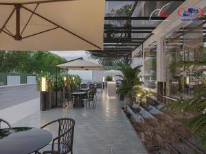 ein Freiluftrestaurant mit Tischen, Stühlen und Sonnenschirmen in der Unterkunft Halora Ten Lua Hotel in Ho-Chi-Minh-Stadt
