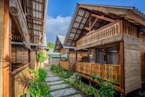 a row of wooden buildings with a walkway between them at Divine Divers Gili Meno in Gili Meno