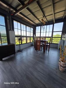 a dining room with a table and chairs and windows at ASHBURN'S TRANSIENT LA UNION - BAUANG, Self Service, Self Check-in, MOTORCYCLE Parking in Bauang