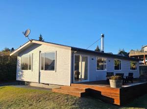 a small white house with a wooden deck at "Great Scott" Great spot your Tekapo Retreat in Lake Tekapo