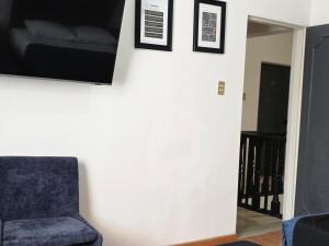 a living room with a chair and a tv on the wall at 25 Habitación doble cama in Miravalle