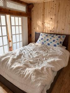 a bed in a room with wooden walls and windows at 스테이여온 in Miryang