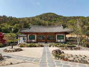 a pavilion in a garden with a mountain in the background at 스테이여온 in Miryang
