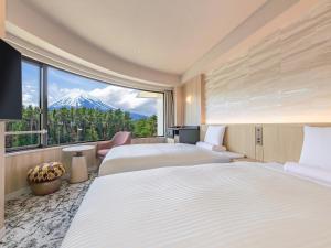 a hotel room with two beds and a large window at KAMENOI HOTEL Fuji in Fujiyoshida