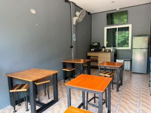 a group of tables and chairs in a kitchen at Friendlyhostel in Khao Sok National Park +55 photos