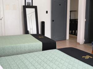 two beds sitting in a room with a mirror at 24 Habitación doble cama in Miravalle +3 photos