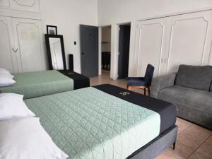 a room with two beds and a couch and a chair at 24 Habitación doble cama in Miravalle