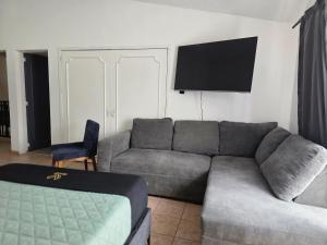 a living room with a couch and a flat screen tv at 24 Habitación doble cama in Miravalle