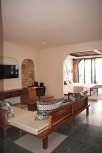 a room with couches and a bed and a tv at The Casa Lunamoon in Kintamani