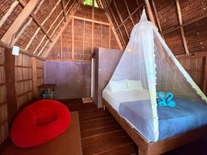 a bedroom with a bed with a net at Warahnus dive homestay in Kri