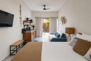 a bedroom with a bed and a tv and a couch at Residencial Mirante in Itacaré