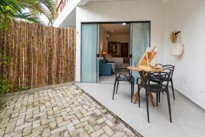 a patio with a table and chairs and a fence at Residencial Mirante in Itacaré