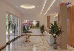 eine Lobby mit Blumen und Pflanzen in einem Gebäude in der Unterkunft Halora Ten Lua Hotel in Ho-Chi-Minh-Stadt