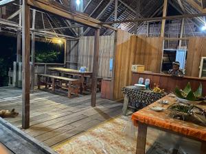 an outdoor dining area with wooden floors and tables at Warahnus dive homestay in Kri