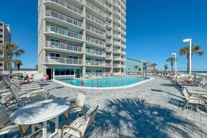 a resort with a pool and chairs and a building at BeachFront, Bottom Level Condo at Tradewinds in Orange Beach