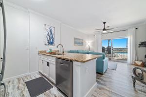a kitchen with a sink and a living room at BeachFront, Bottom Level Condo at Tradewinds in Orange Beach