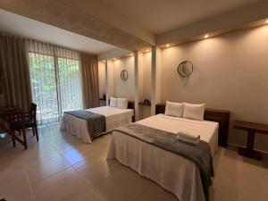 pokój hotelowy z dwoma łóżkami i oknem w obiekcie Cuatro Lunas Hotel Boutique w mieście Palenque