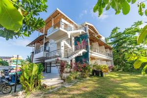 a house with balconies and a yard at Reside Siargao in General Luna