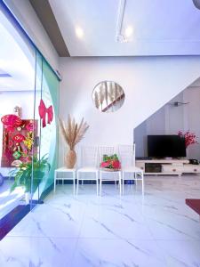 a living room with two white chairs and a television at Hoàng Nga 1 Apartment in Phan Thiet