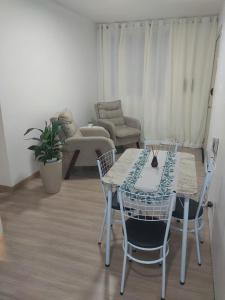 a dining table and chairs in a living room at Apto terreo bem arejado e iluminado in Gravataí