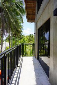 a balcony of a house with a gate and palm trees at yolked suites in General Luna