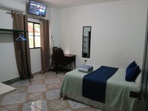 a bedroom with a bed and a desk and window at Tunco SurfHouse in El Sunzal
