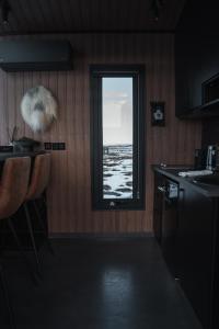 a kitchen with a window with a view of the ocean at Tiny Glass lodge in Selfoss
