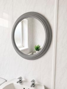 a bathroom mirror with a sink and a window at Cozy Corner in Wolverhampton City Centre in Wolverhampton
